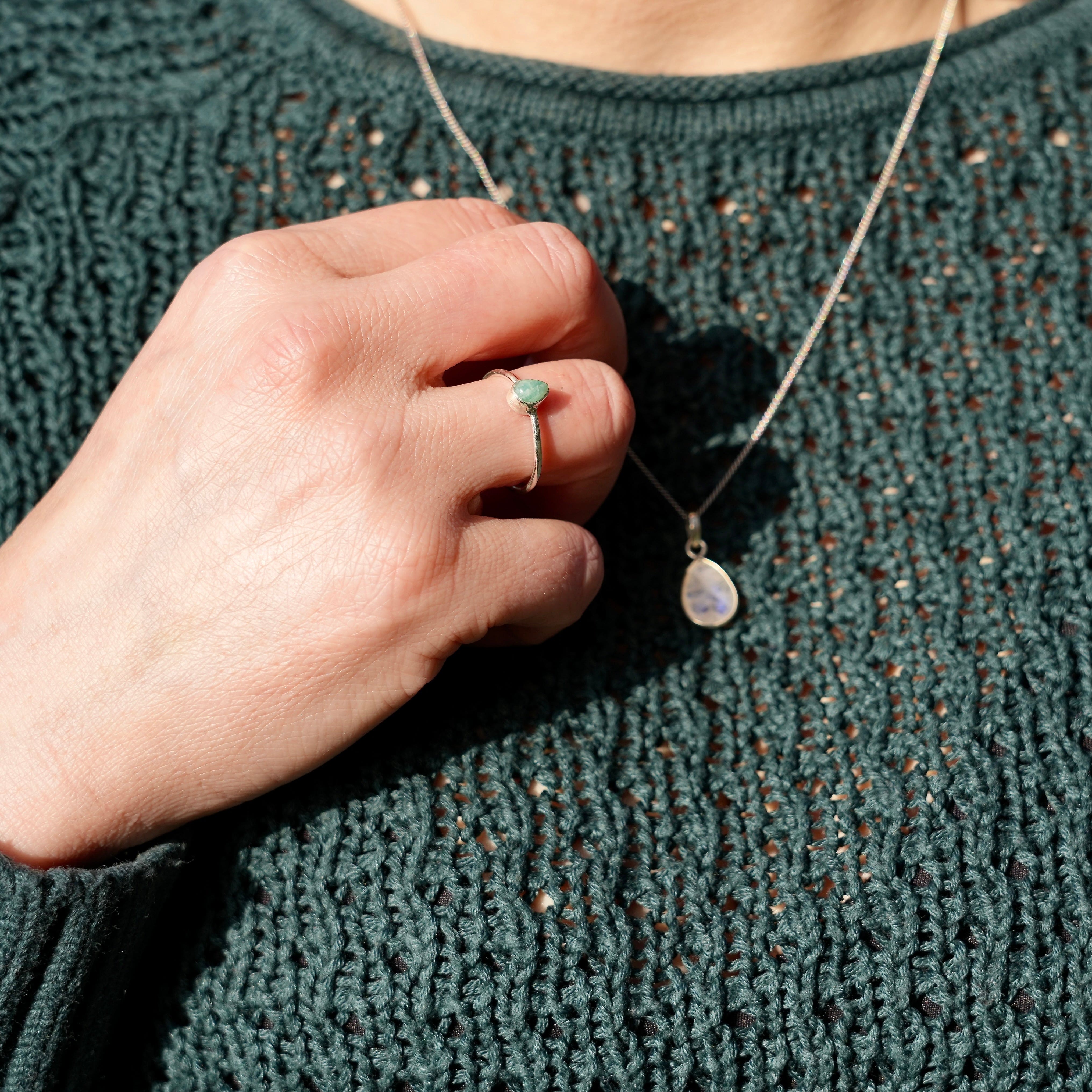 Foto van hand met ring met Amazoniet en een halsketting met een maansteen