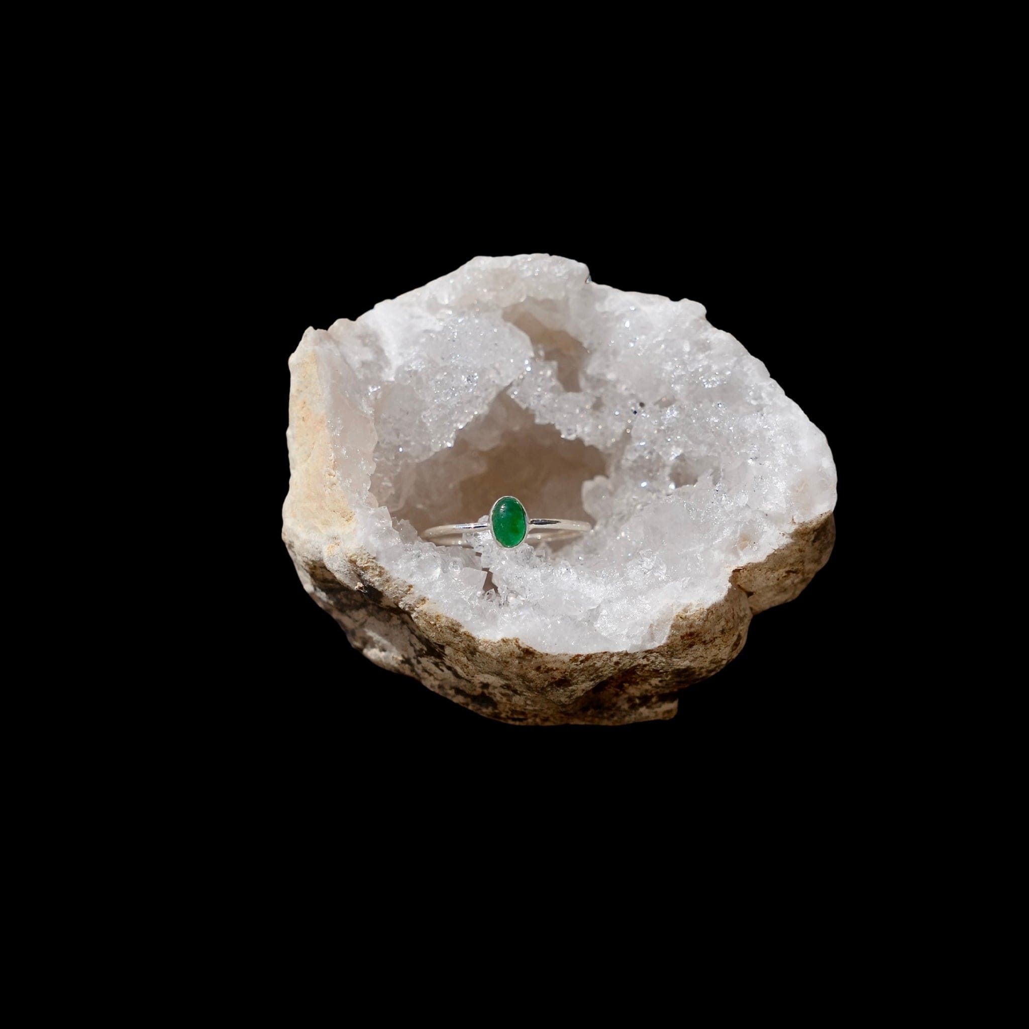 Zilveren minimalistische ring met een ovale Aventurijn edelsteen, gefotografeerd in een bergkristal geode