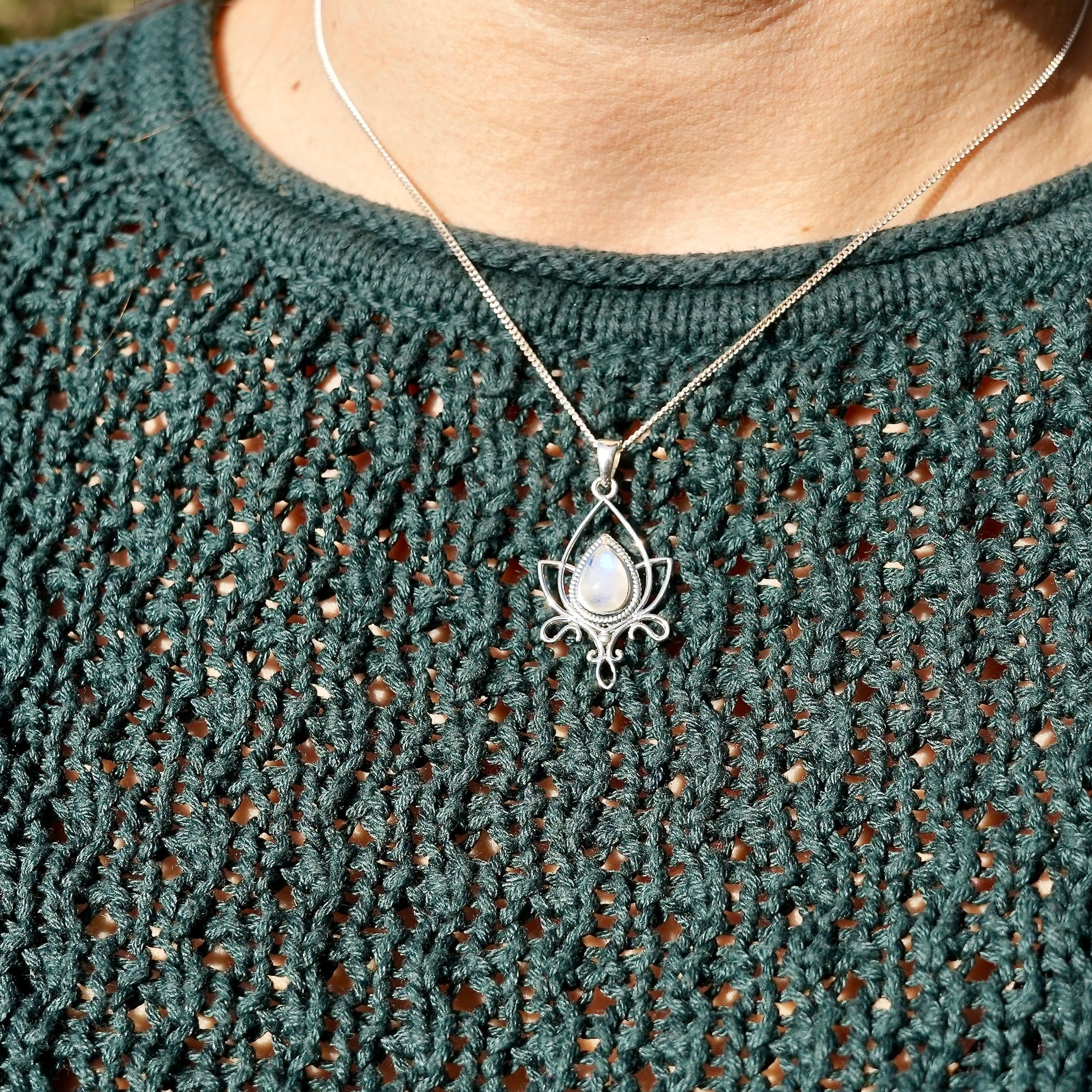 Persoon met halsketting met sierlijke lotus met maansteen in druppelvorm