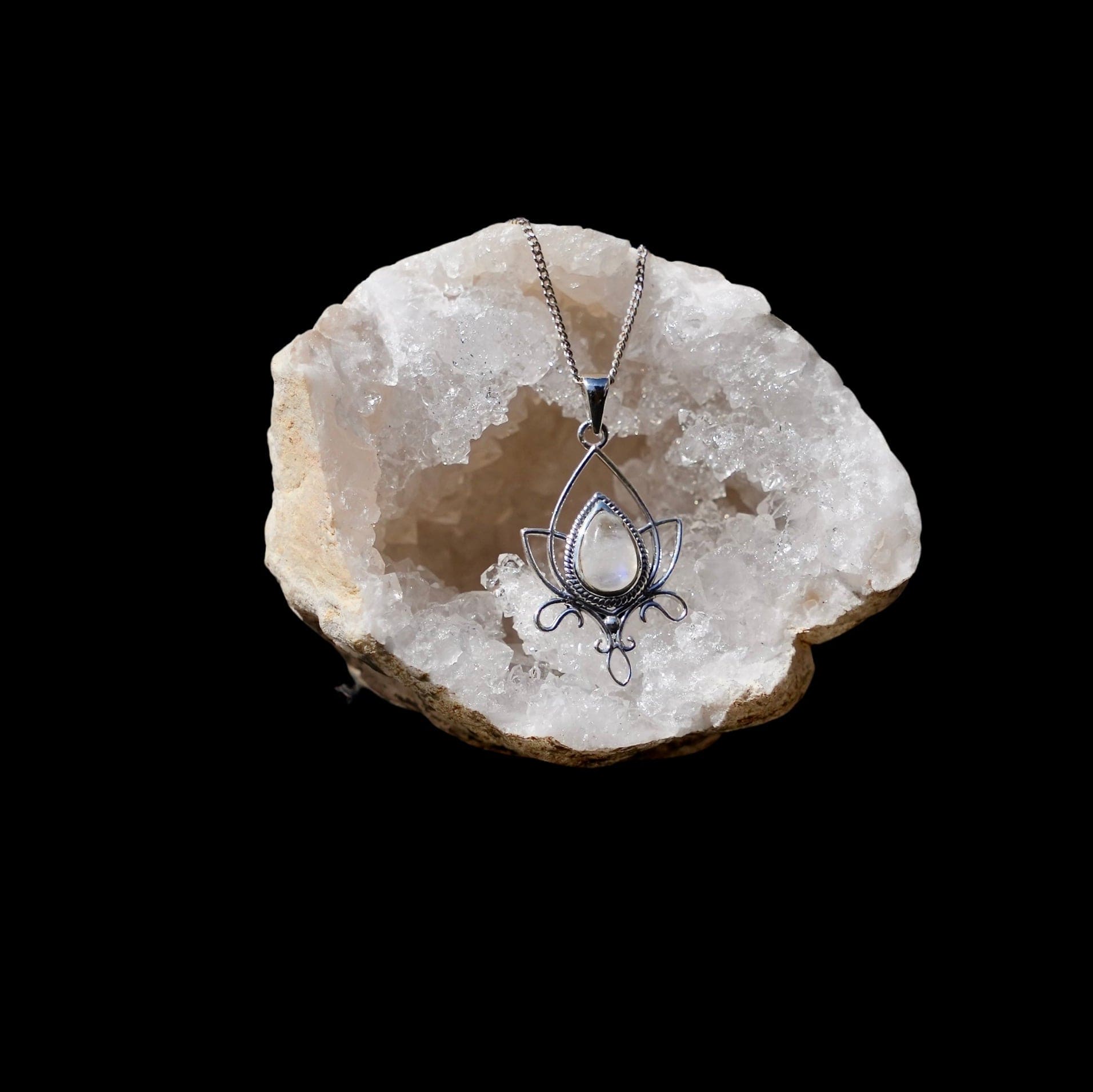 Sierlijke lotushanger met maansteen in druppelvorm gefotografeerd in een quarts geode.
