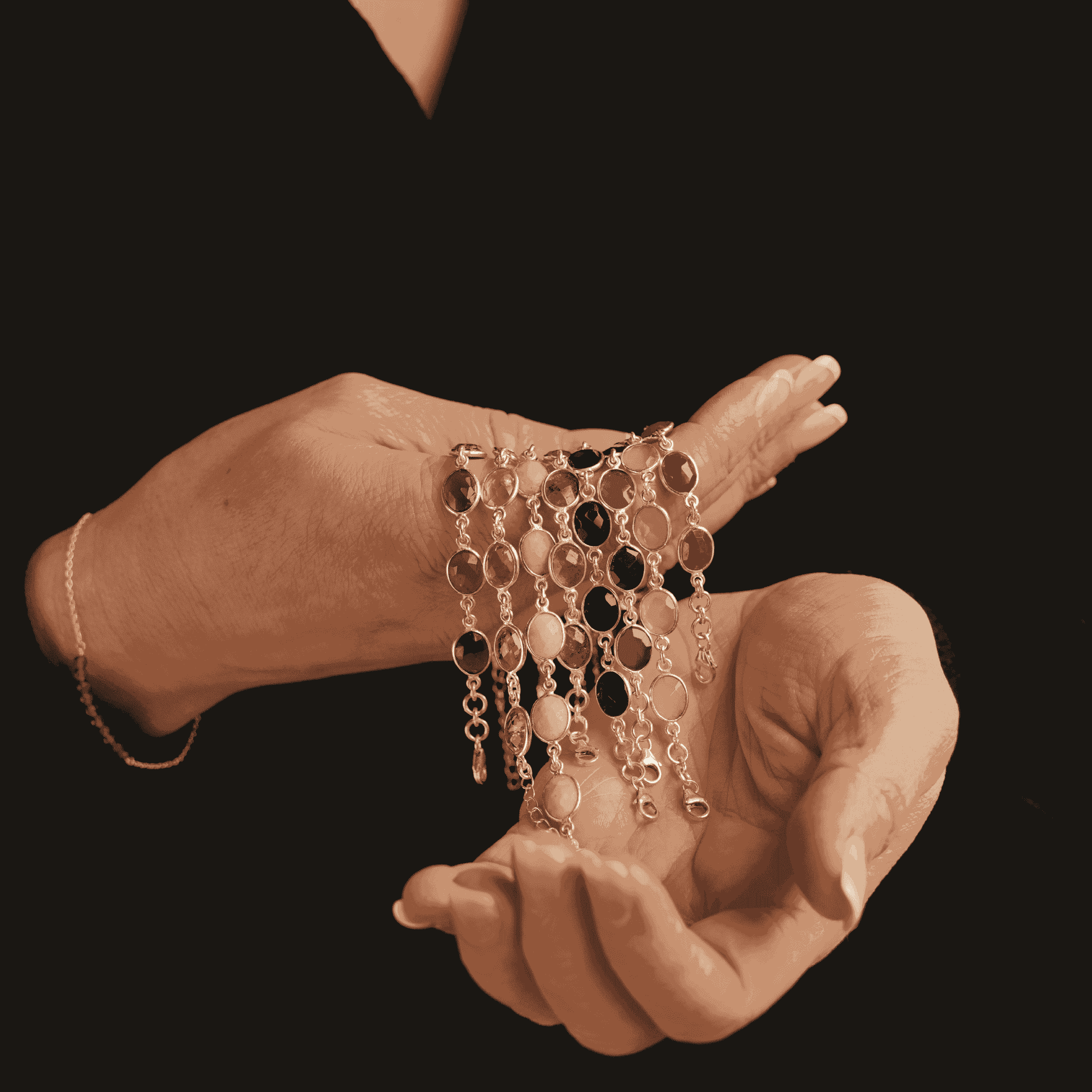 diverse armbanden et diverse facet geslepen edelstenen vastgehouden in twee handen