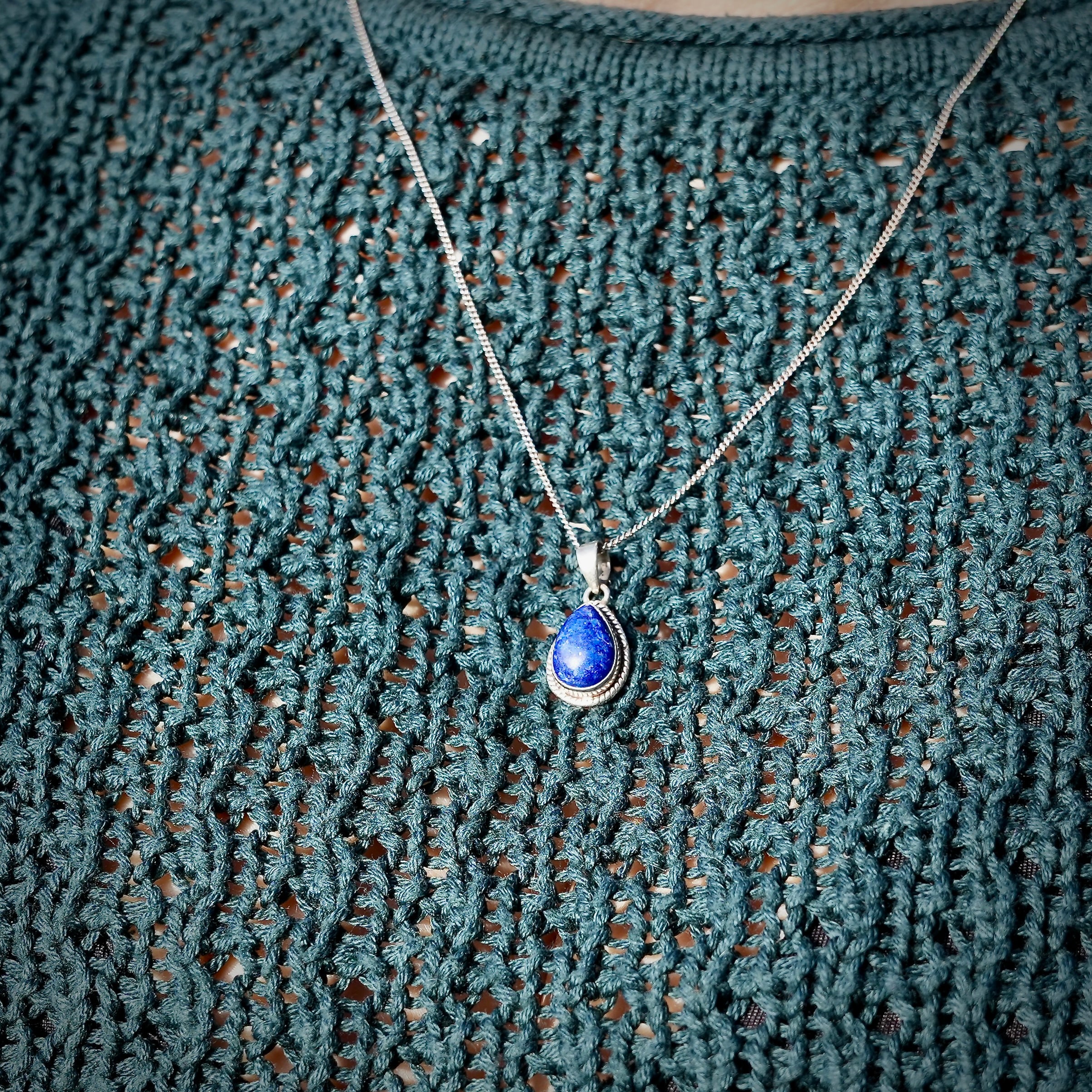 Persoon met Halsketting met zilveren hanger Nubbu met Lapis lazuli en zilveren omlijsting - Juwelen uit de Natuur