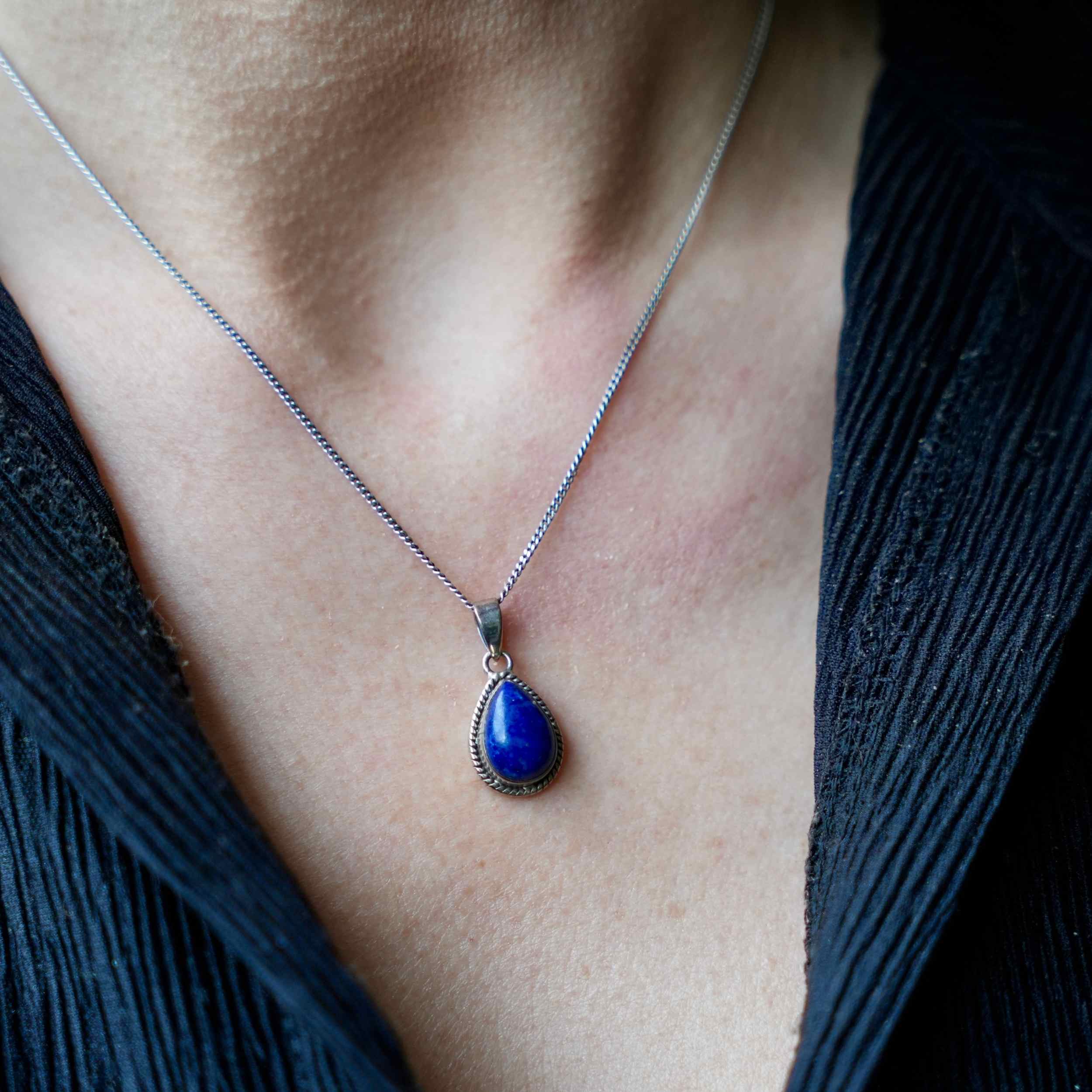 Persoon met Zilveren halsketting met  hanger Nubbu van Lapiz Lazuli in druppelvorm - Juwelen uit de natuur
